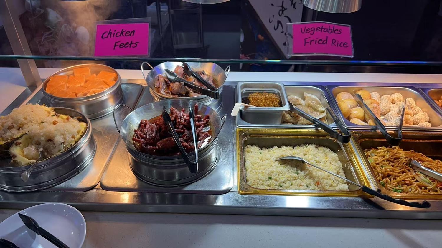 Metal steam pans with braised chicken feet and vegetable fried rice at YC Seafood Hot Pot, a Hot Pot Restaurant in Virginia Beach