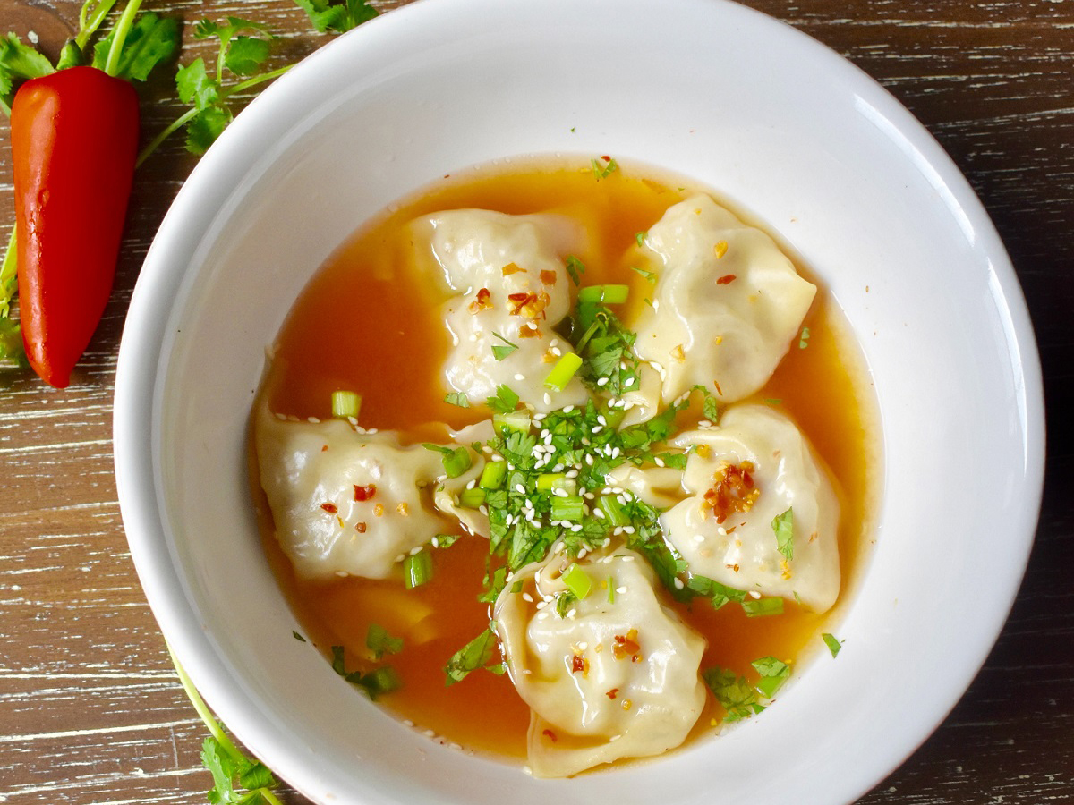 Baobao-Dim-Sum & Authentic-Chinese-Cuisine-Restaurant-Spicy-Wonton-in-Chili Oil-Huntersville a black bun next to a steamer