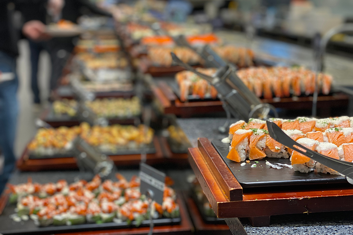 Neat rows of fresh salmon sushi rolls on wooden serving platters at Yummy Buffet Asian Cuisine, an Asian Restaurant in Sikeston