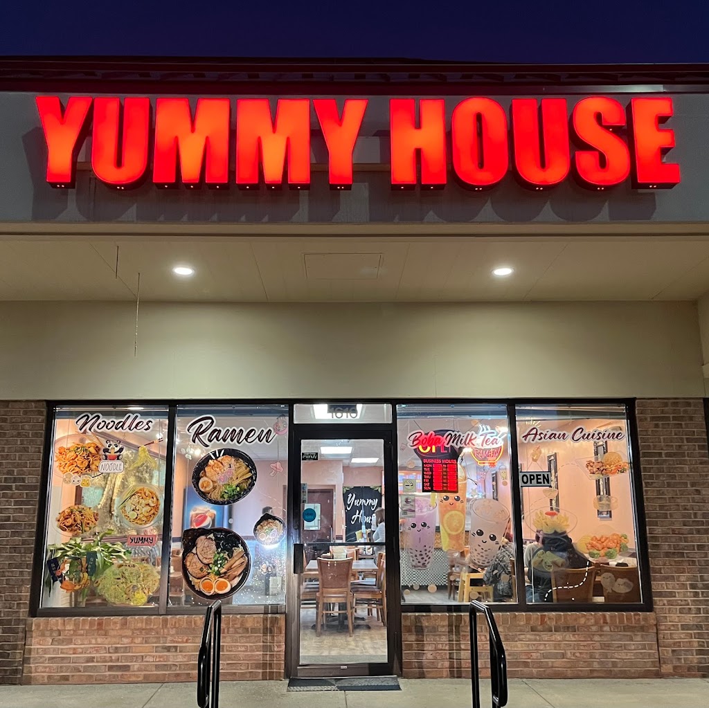 Night exterior of Yummy House Asian restaurant with bright red illuminated sign