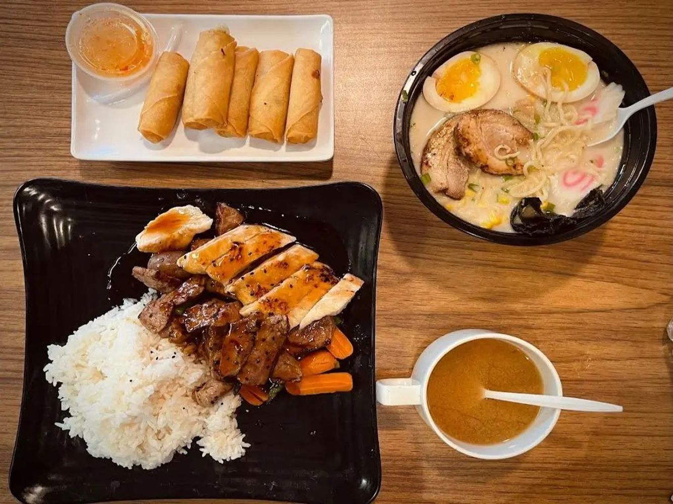 Assorted Asian meal set with spring rolls, ramen, teriyaki rice and soup