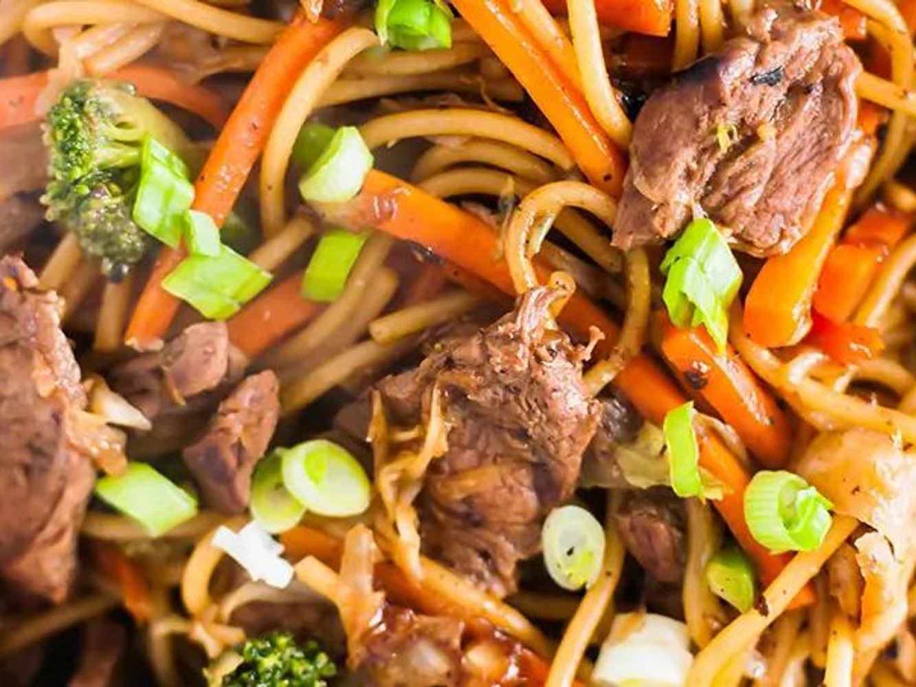Beef lo mein stir-fried noodles with carrot, broccoli and green onion