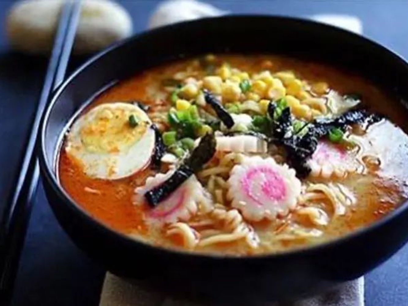 Spicy creamy ramen topped with corn, seaweed and soft boiled egg