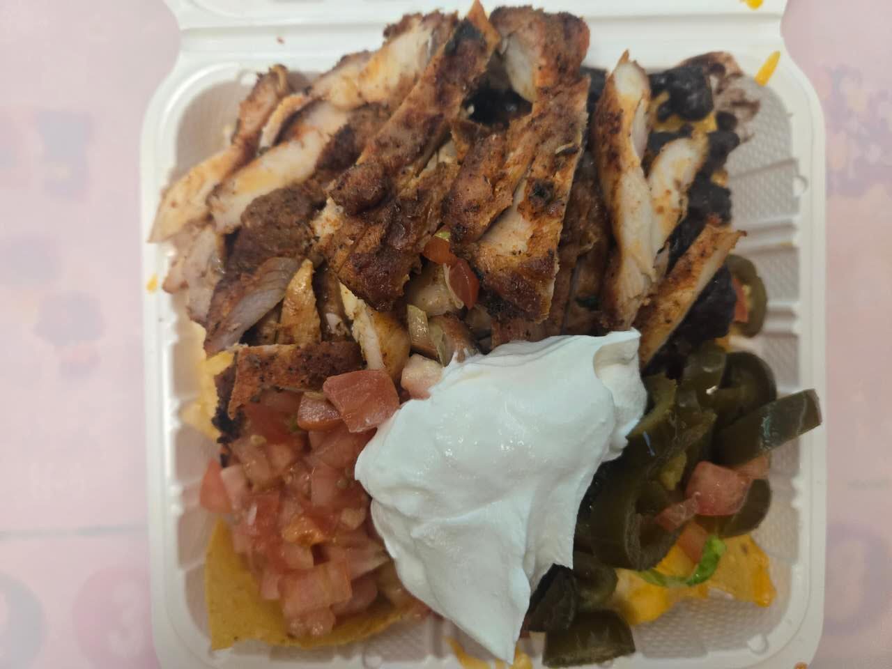 Chicken nachos with sour cream and jalapenos at No.1 Yummy Taco, a Mexican Restaurant in South Ozone Park