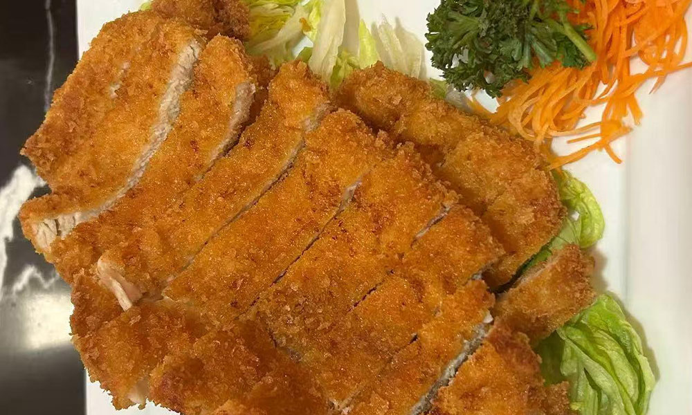 Crispy breaded pork katsu served with shredded lettuce and carrot garnish at Yu San, a Japanese Restaurant in East Stroudsburg