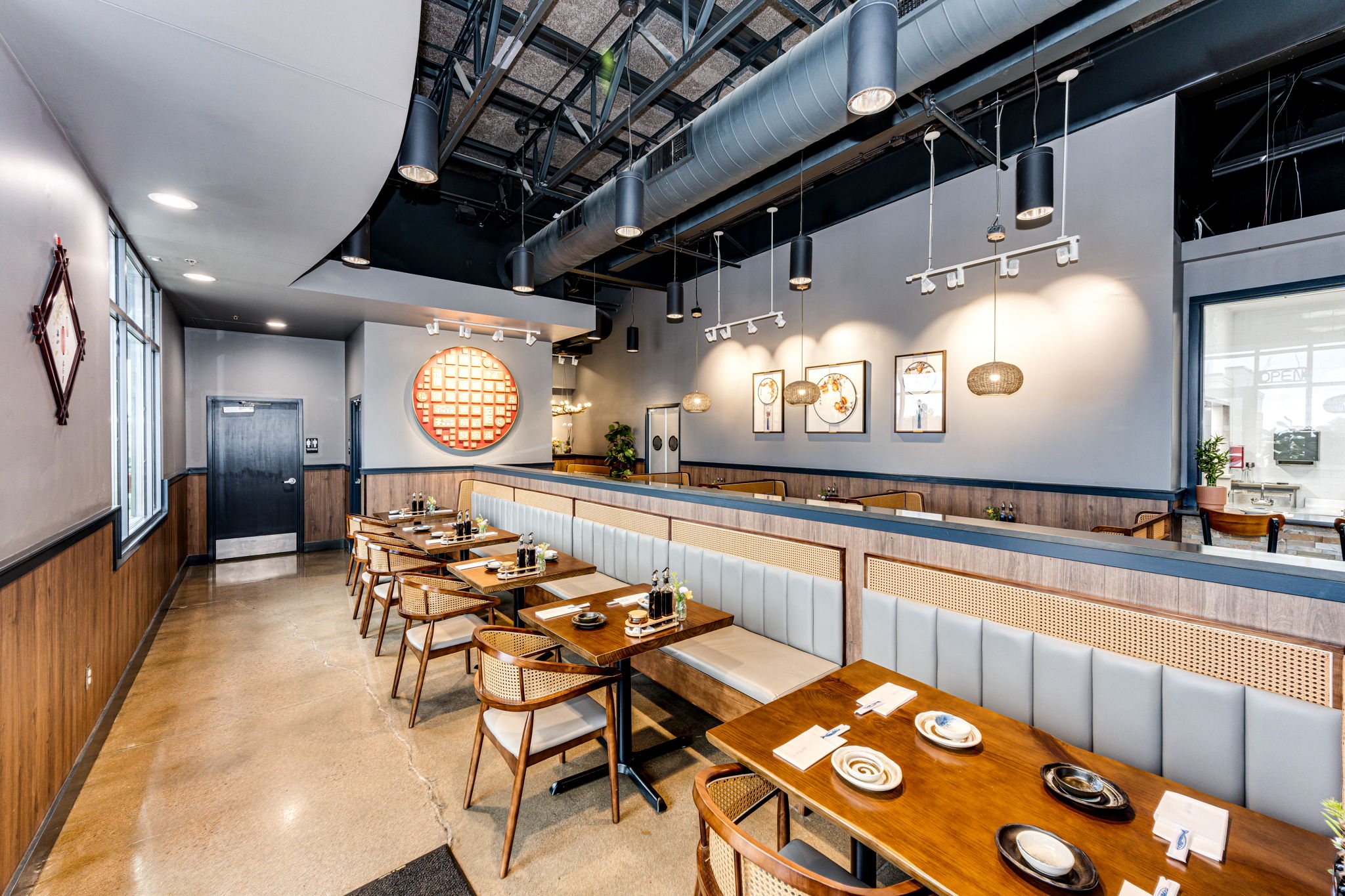 Yu's-Noodle-Shop-Chinese-restaurant-Lone-Tree Modern dining area with wooden tables, booths, and decorative lighting at a restaurant.