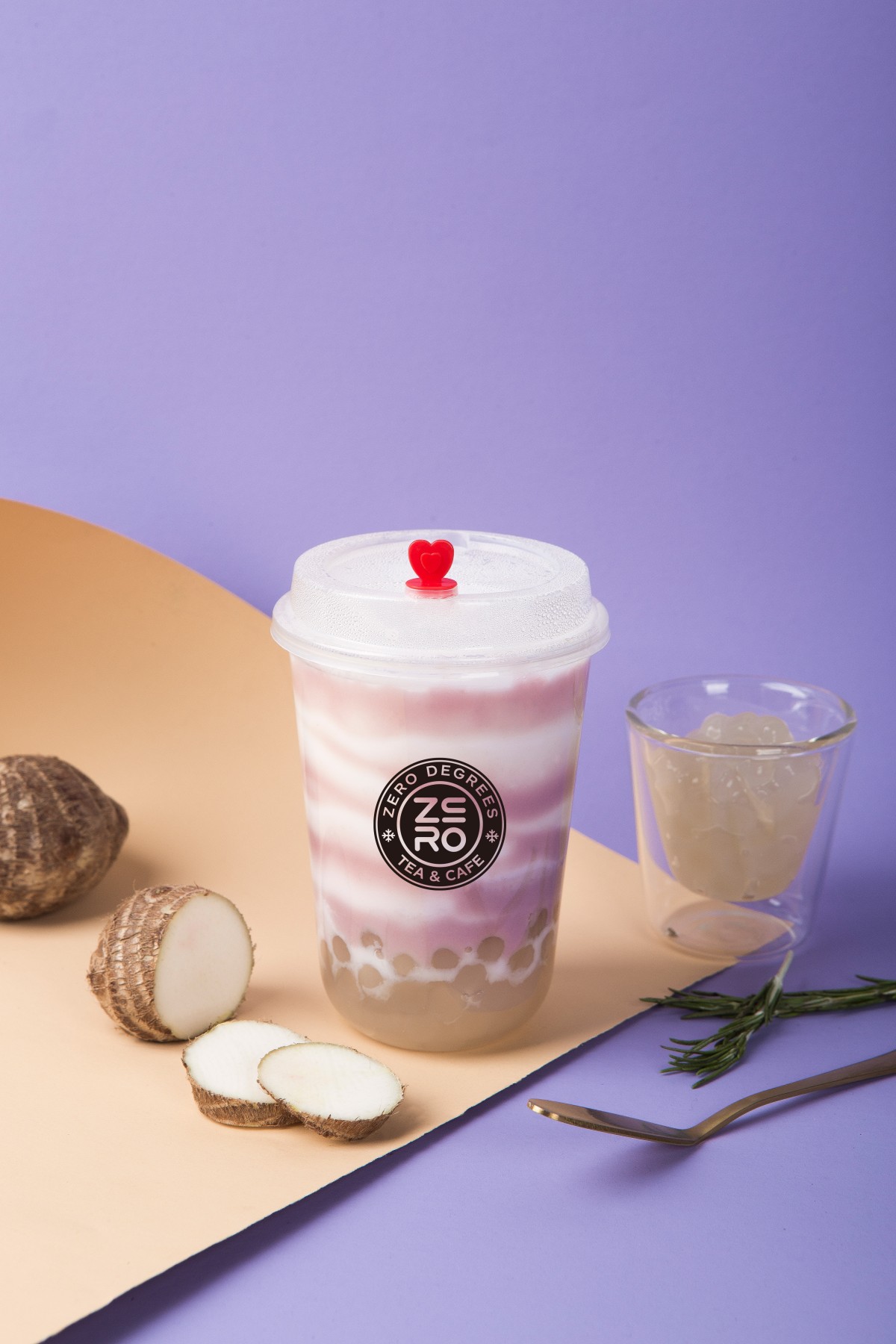 Zero-Degrees-Asian-inspired-Drink & Snack-Shop-Taro-Boba-Milk-Tea-Bloomington A cup of taro boba milk tea with taro roots and a glass of jelly beside it at Zero Degrees,a Asian-inspired Drink & Snack Shop in Bloomington