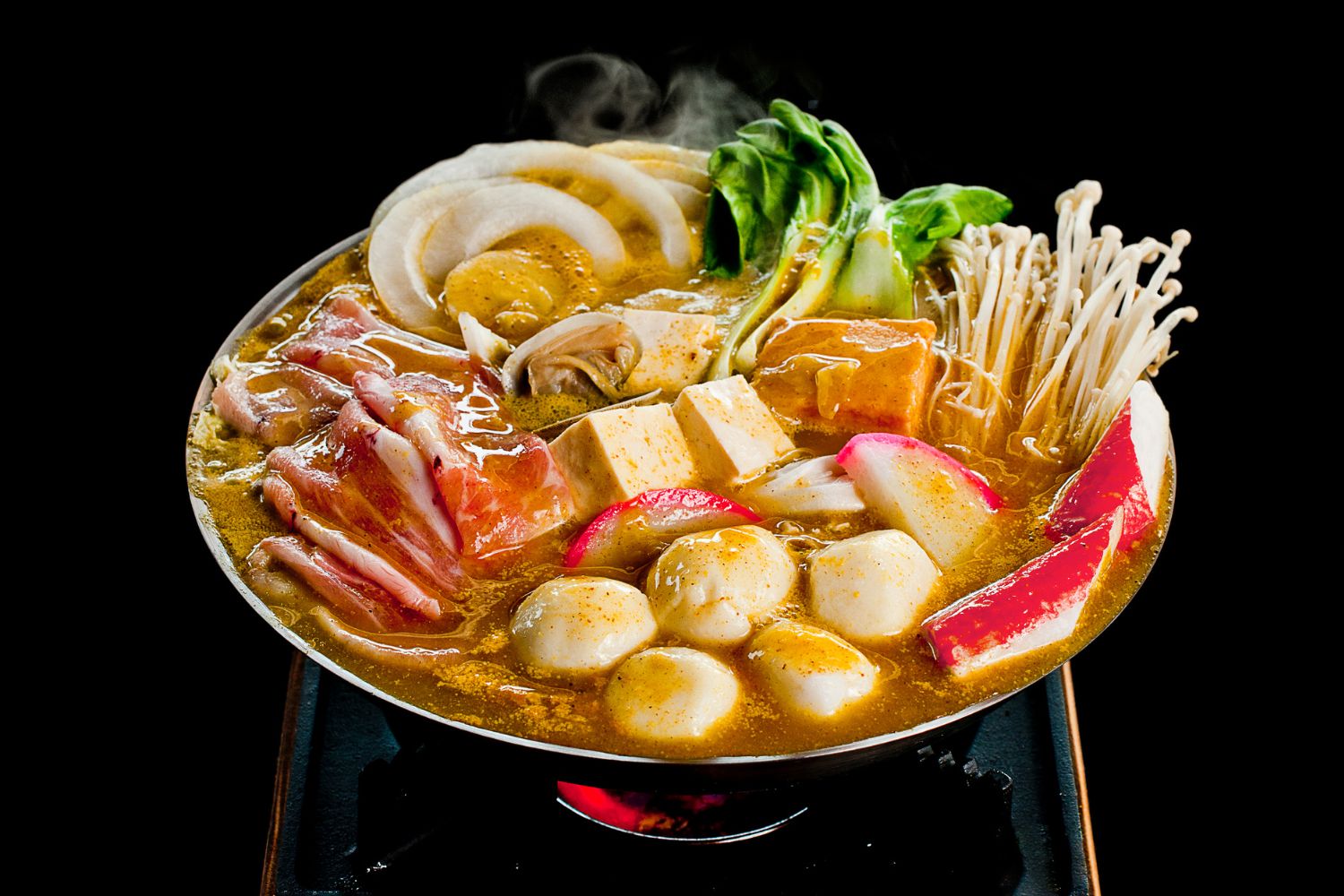 Fully cooked golden broth hot pot with pork, tofu, crab stick, fish balls and greens at ZhangLiang Malatang - Corona, a Chinese Restaurant in Corona