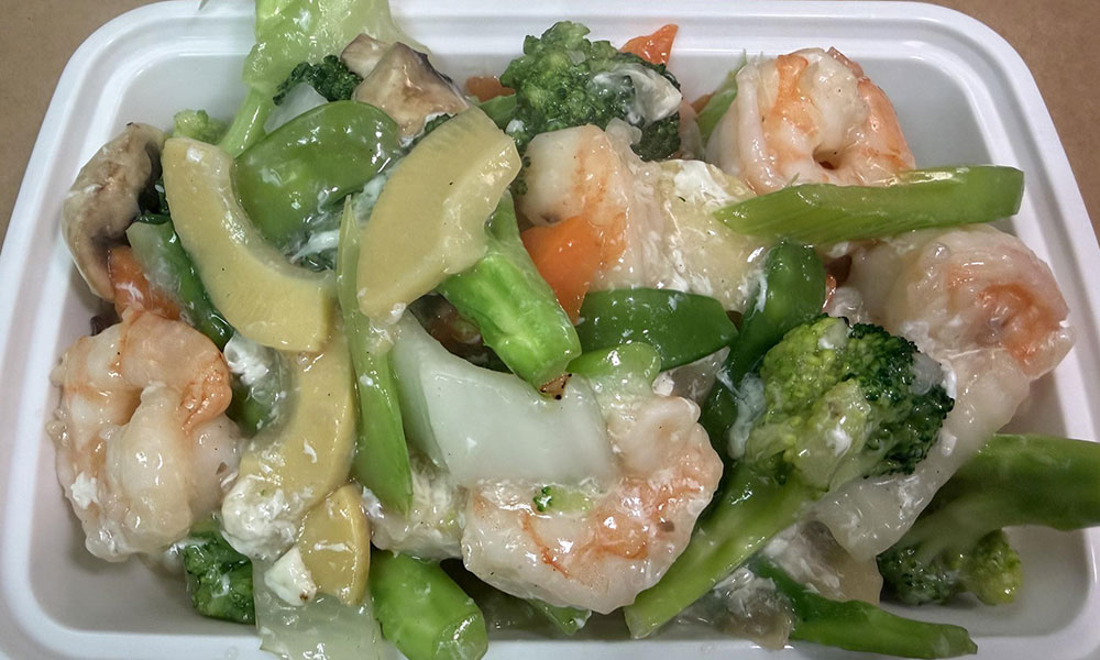 Shrimp with mixed vegetables in creamy white sauce, Chinese takeout style.