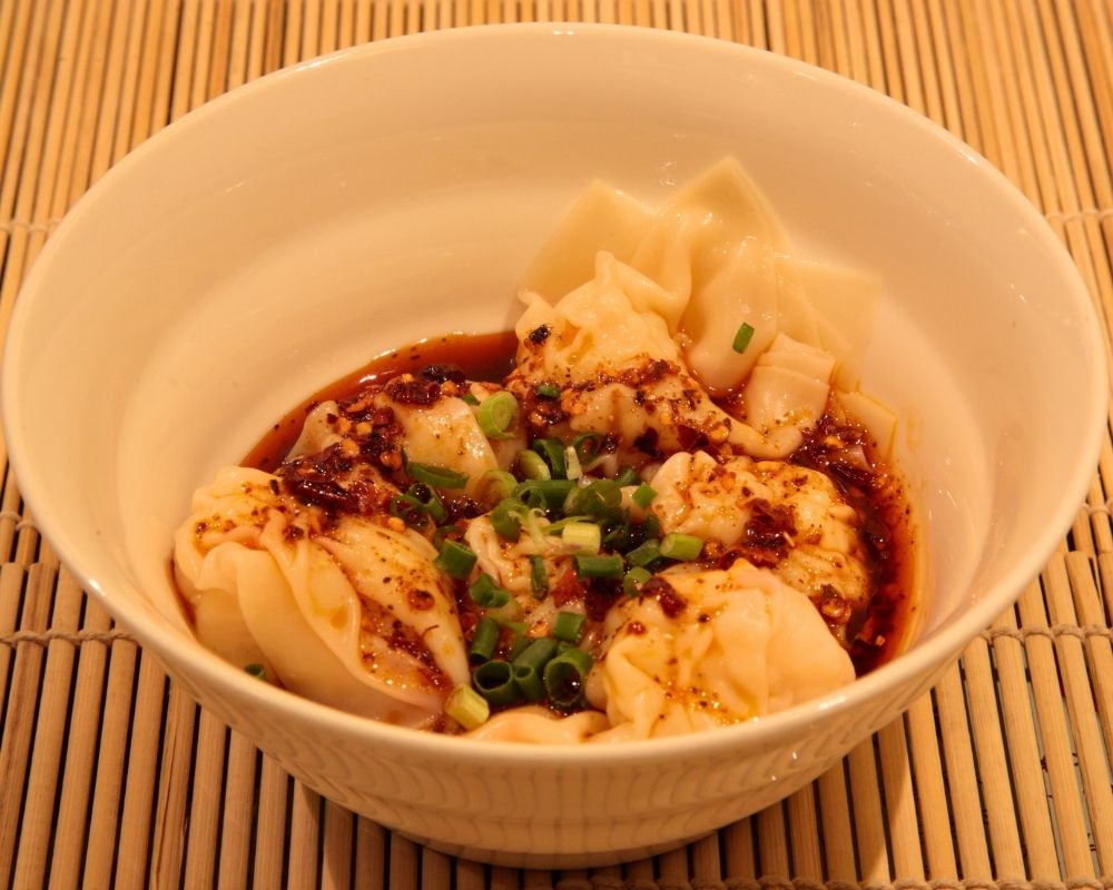 Spicy wontons in chili oil with scallions at ZOEN RAMEN & POKE, Ramen Restaurant in College Station