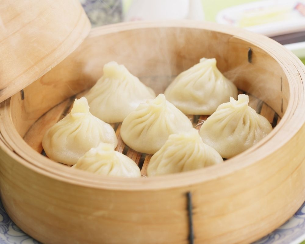 Steamed soup dumplings in bamboo steamer at ZOEN RAMEN & POKE, Ramen Restaurant in College Station